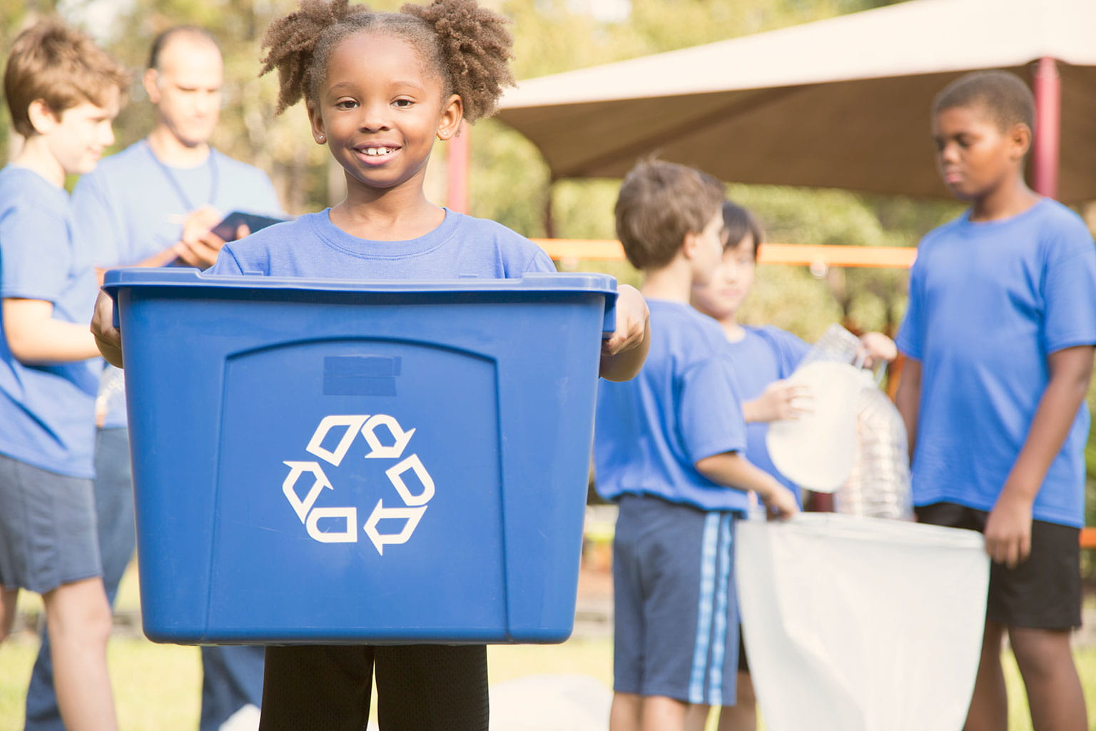 A group of kids volunteering and recycling trash