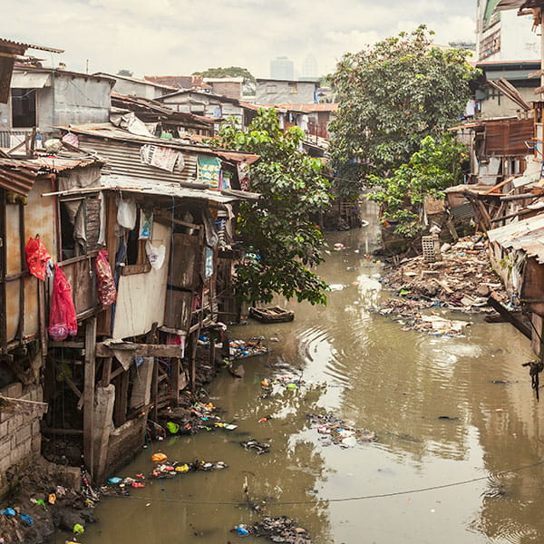 A filthy water canal between two rows of houses